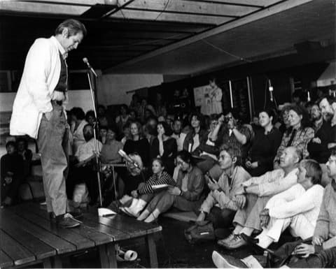 Ben Vautier describes his shoes to the audience (Photo: Michael Lange, 1985)
